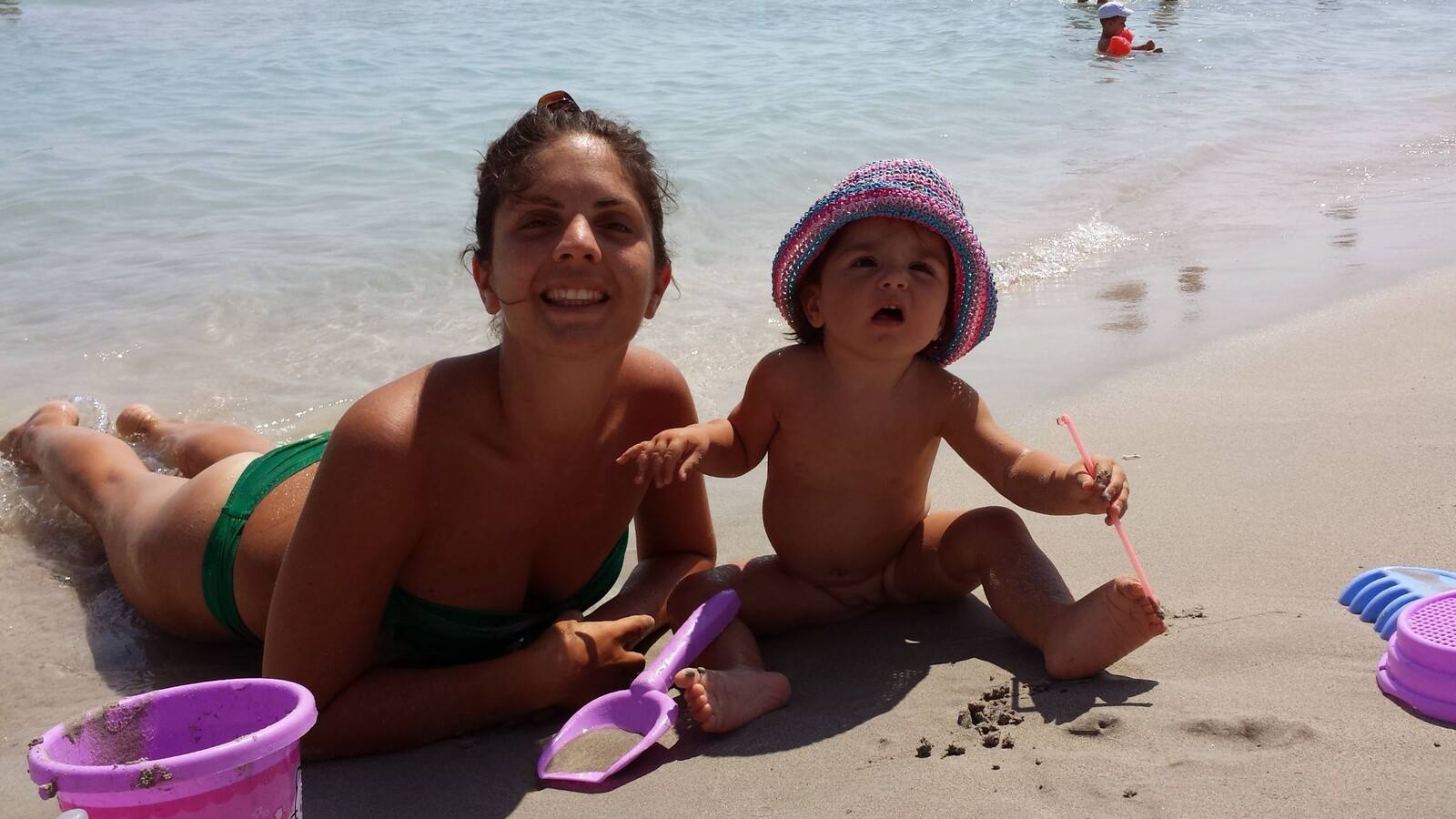Giocando con la sabbia al mare, sorridenti e pieni di sole.