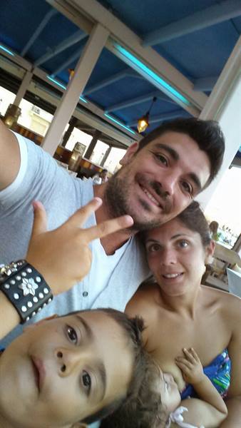 Un selfie di famiglia pieno di sorrisi al chiosco in spiaggia.