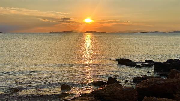 Il sole tramonta sul mare: un ricordo d'oro da incollare nel diario.