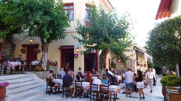 Pomeriggio lento tra tavolini all'aperto e profumi di Grecia.