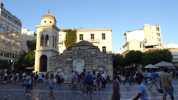 Piazza greca al tramonto: la vecchia chiesa custodisce la vivace quotidianità.