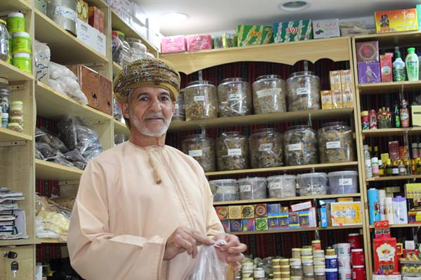 Il sorriso più caldo del souk, tra barattoli di spezie e mille profumi.