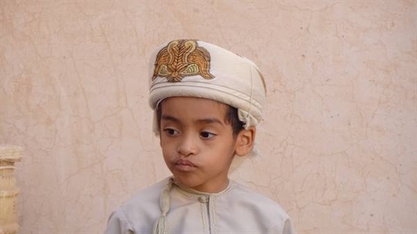 Sguardo serio e cappello ricamato: un piccolo principe d'Oman.