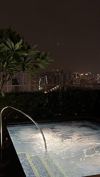 Una piscina calda e la città che brilla nel buio.