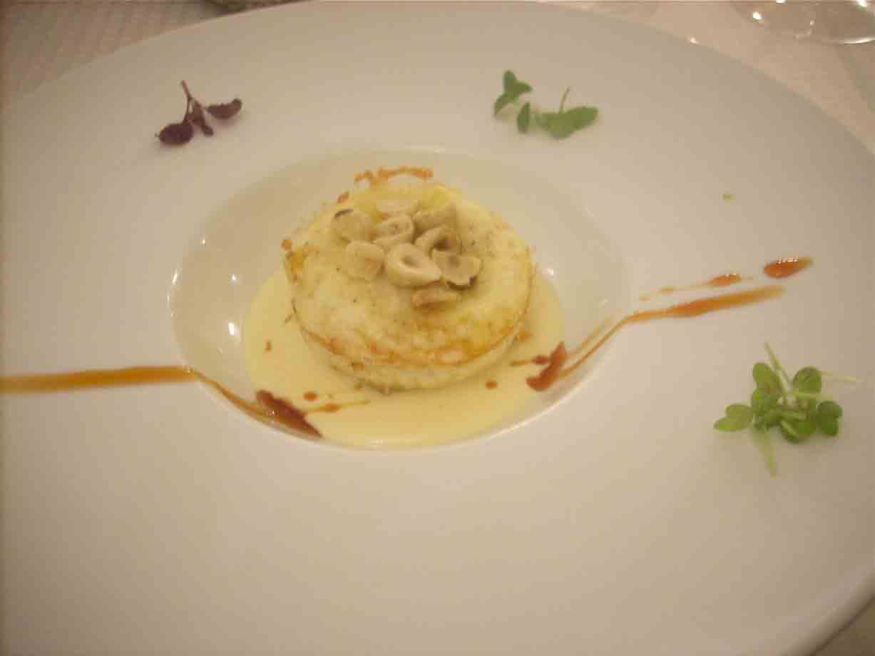 Uovo in forma dal tuorlo fondente su zabaione di grana padano e nocciole tostate
