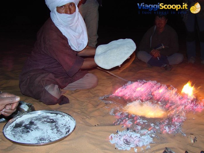 preparazione della Taajeelah- pane cotto sotto la sabbia