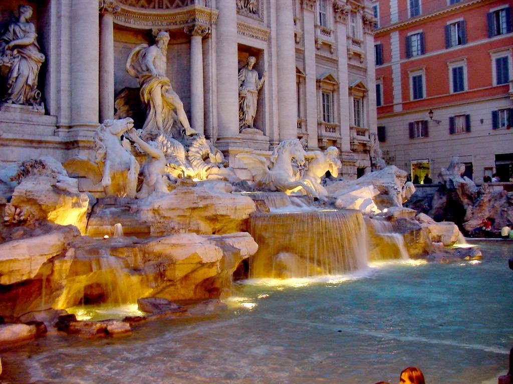 Fontana di Trevi di notte, statue illuminate e cascate nella vasca