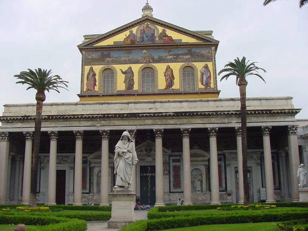 Statua di San Paolo davanti alla basilica con mosaici dorati e palme