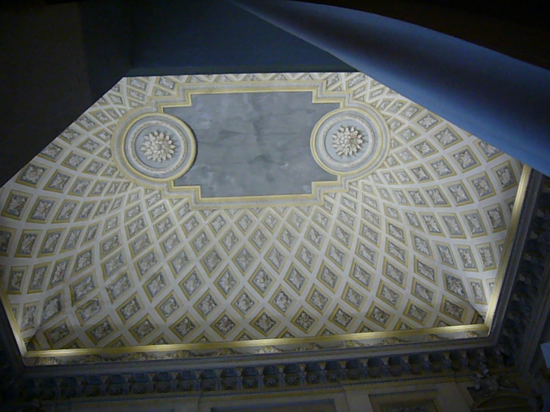 Soffitto a cassettoni bianchi e oro con rosoni in stucco, visto dal basso