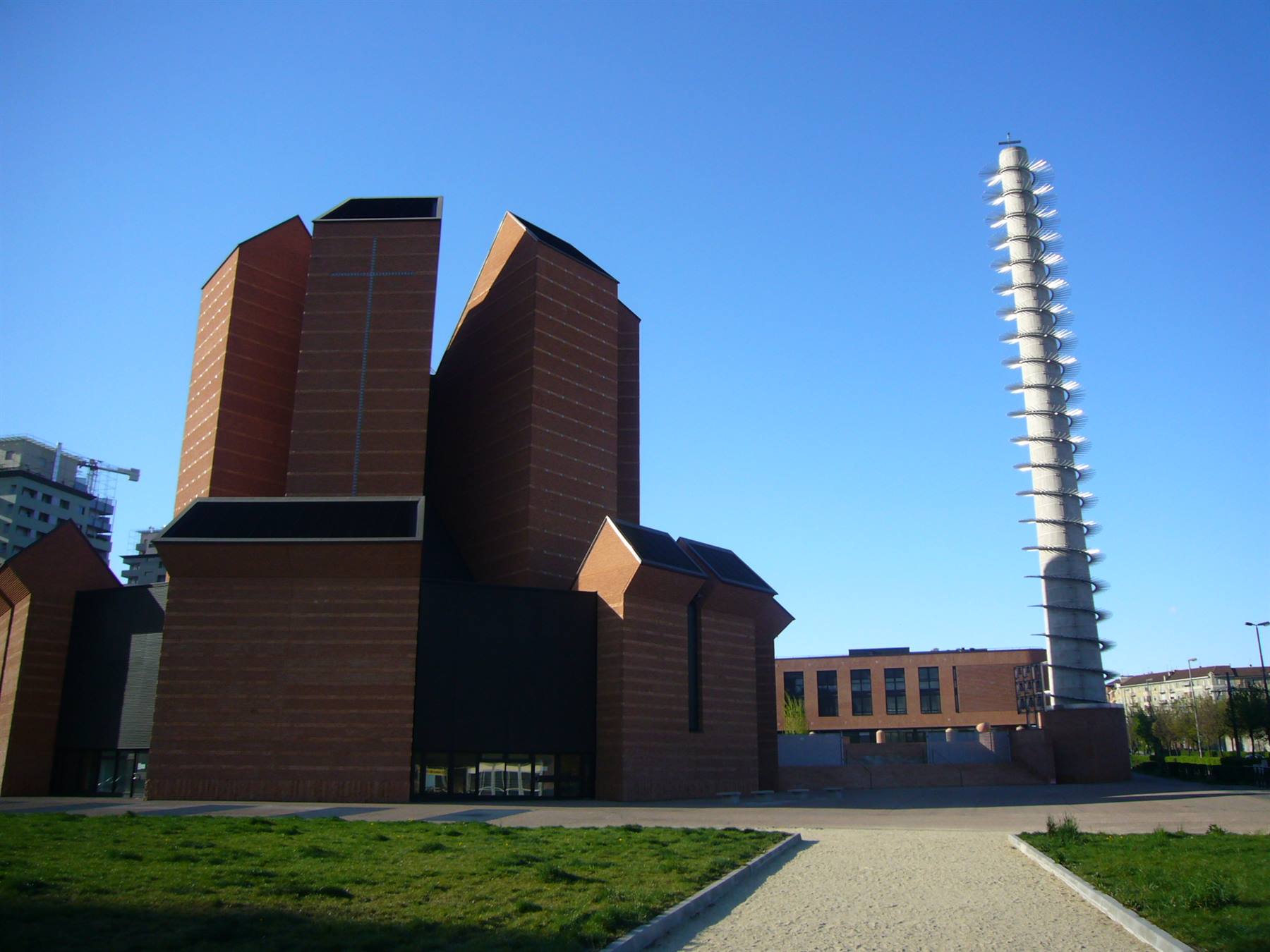 Chiesa in mattoni rossi con campanile a spirale sotto cielo azzurro