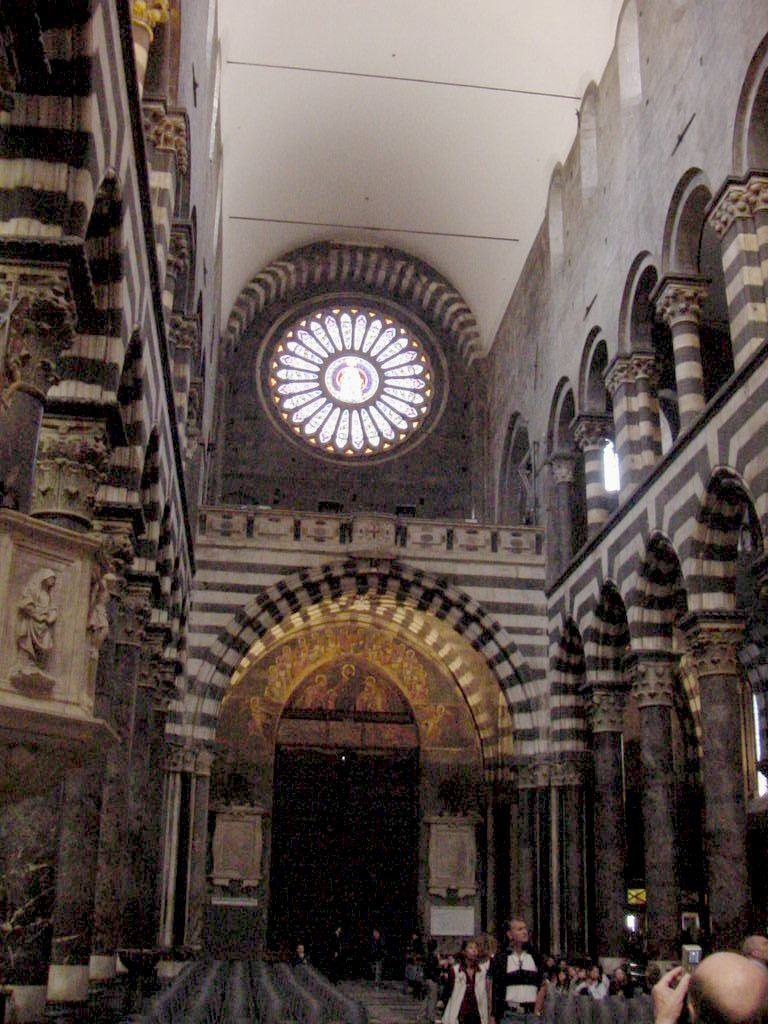 Interno del Duomo di Genova, rosone e mosaico dorato sopra il portale