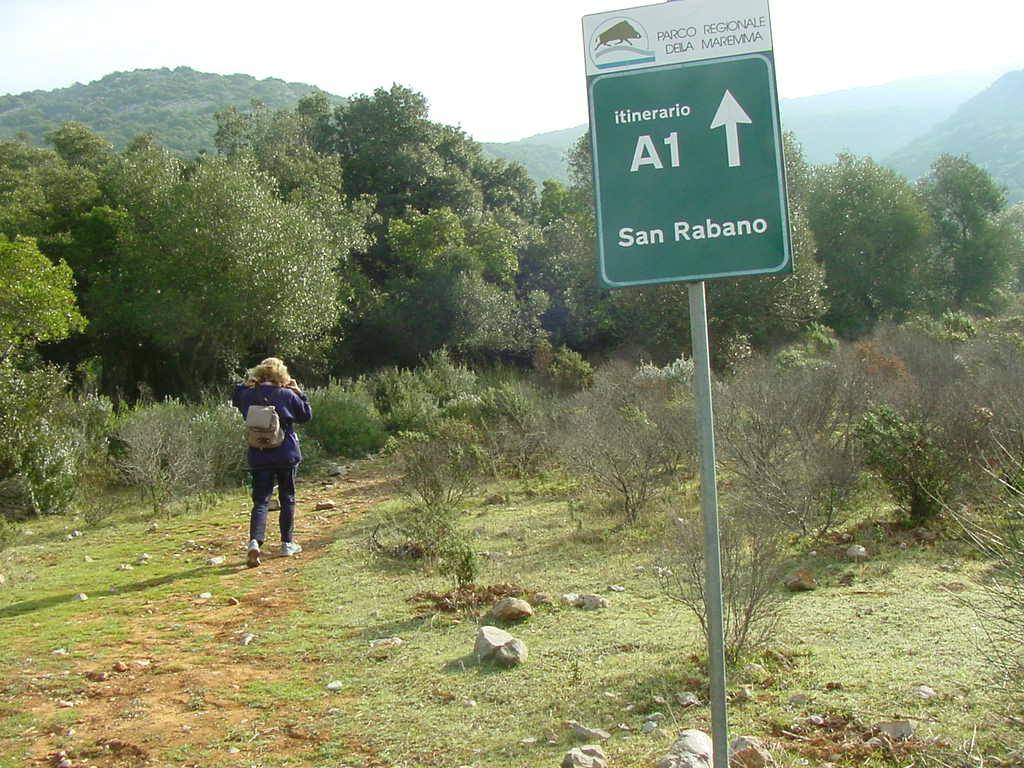 Cartello del Parco della Maremma: itinerario A1 per San Rabano, escursionista sul sentiero