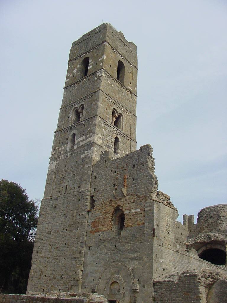 Campanile romanico in pietra dell'abbazia di San Rabano, rovine sotto cielo grigio
