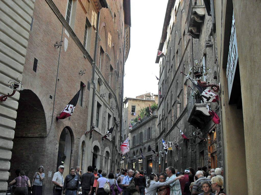 bandiere e folla nelle vie di Siena