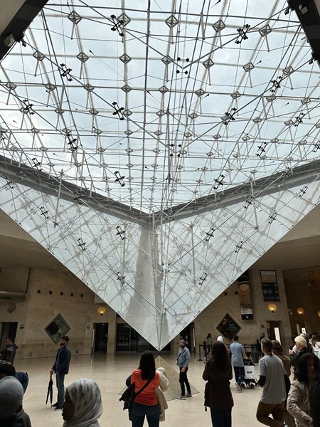 Sotto la piramide invertita del Louvre, un momento di meraviglia condivisa.