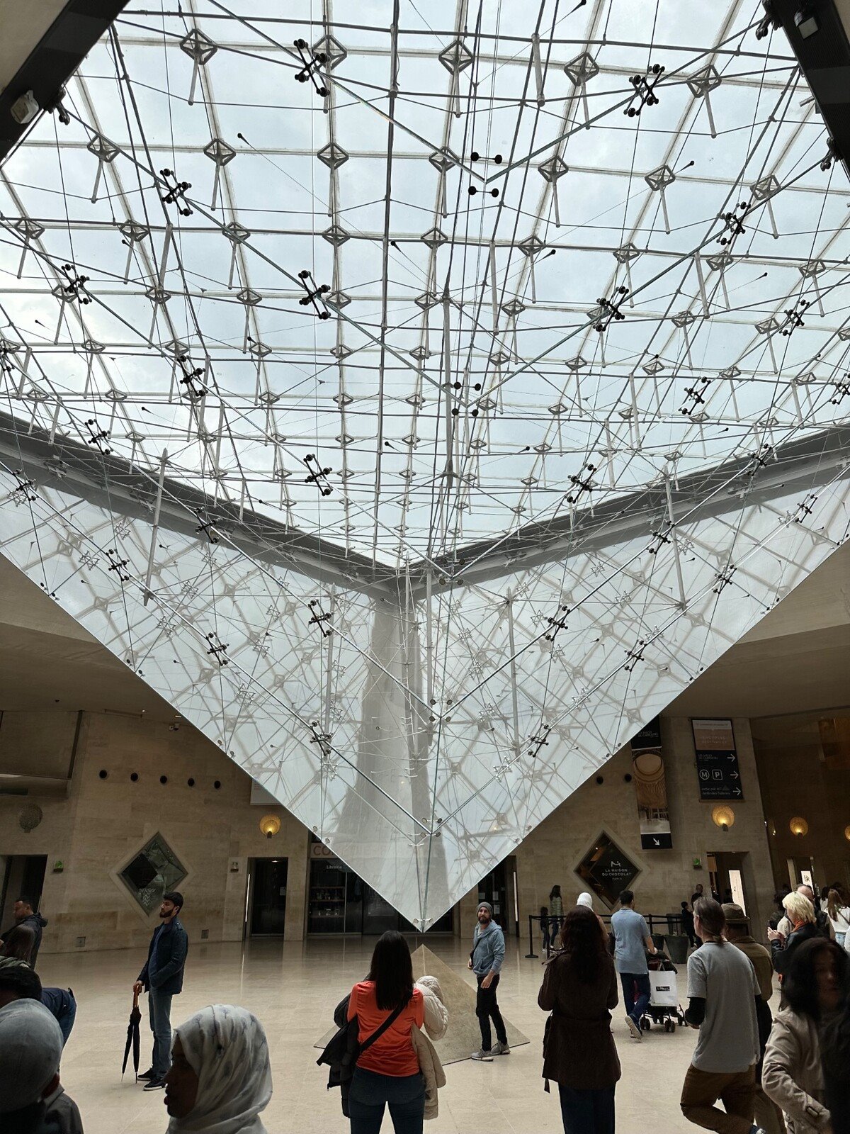 Sotto la piramide invertita del Louvre, un momento di meraviglia condivisa.