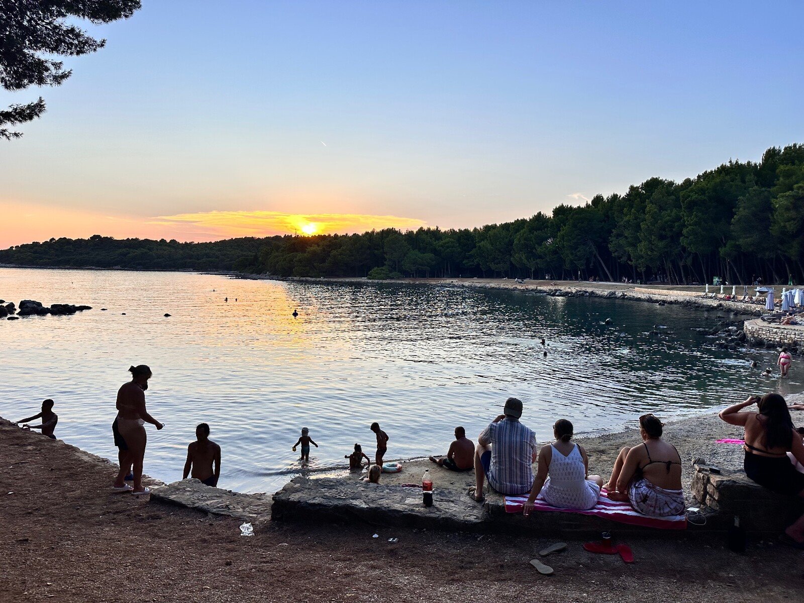 Tramonto sulla caletta: bagni al crepuscolo e cieli che si tingono d'oro.