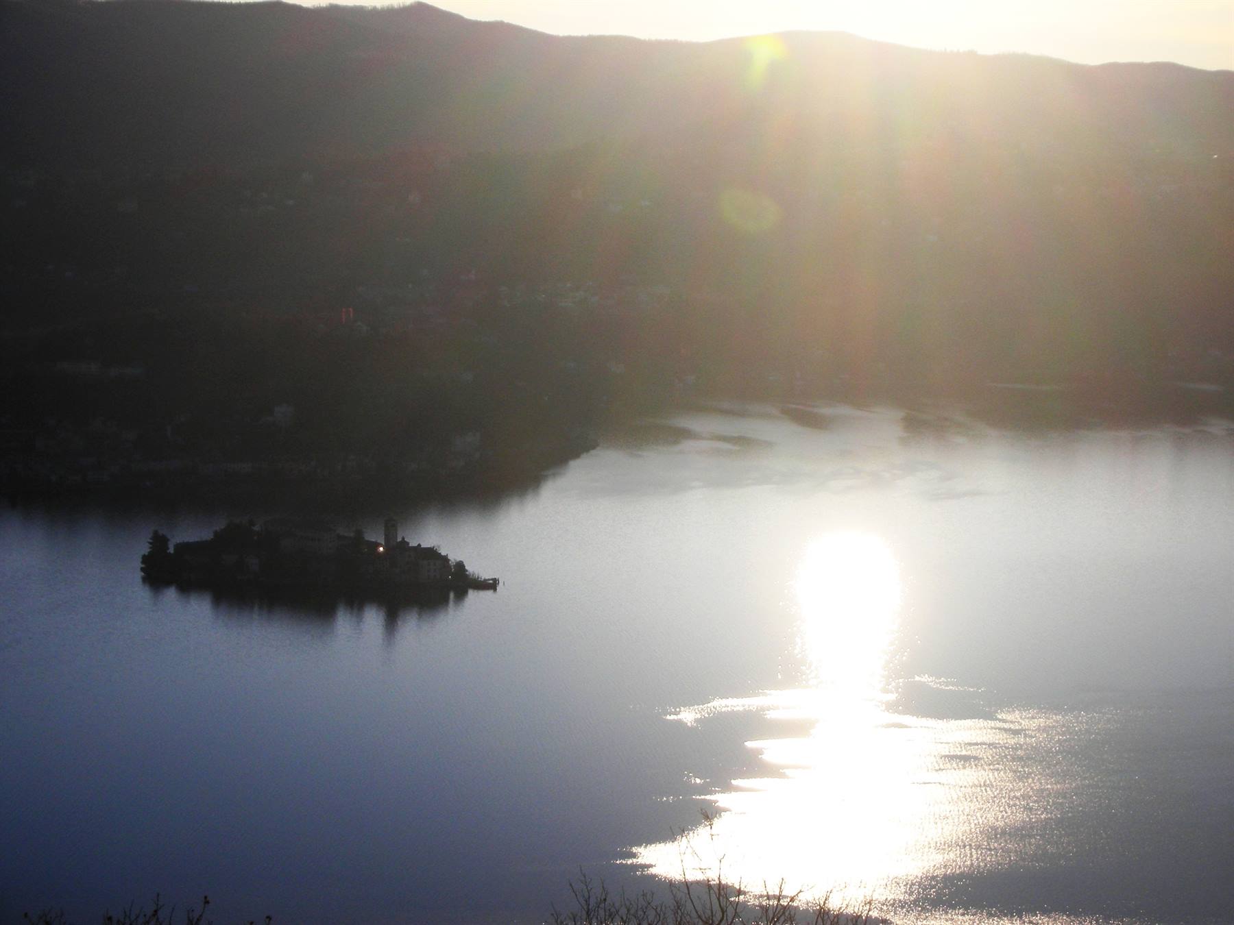alba, lago ed isola con riverbero del sole