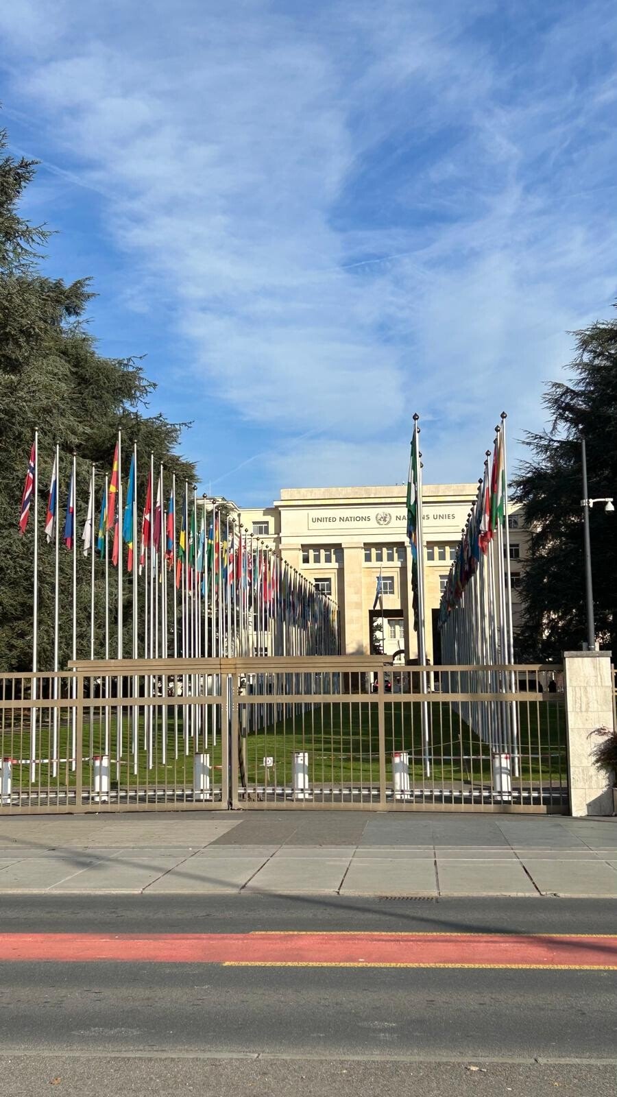 Davanti al Palais des Nations di Ginevra, tra bandiere al vento e cielo azzurro.