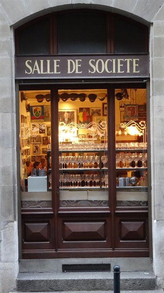 Davanti alla "Salle de Société", vetrina calda di bicchieri e ricordi.