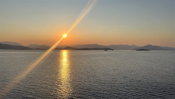 Tramonto dorato sul mare: il viaggio ci regala un momento perfetto.