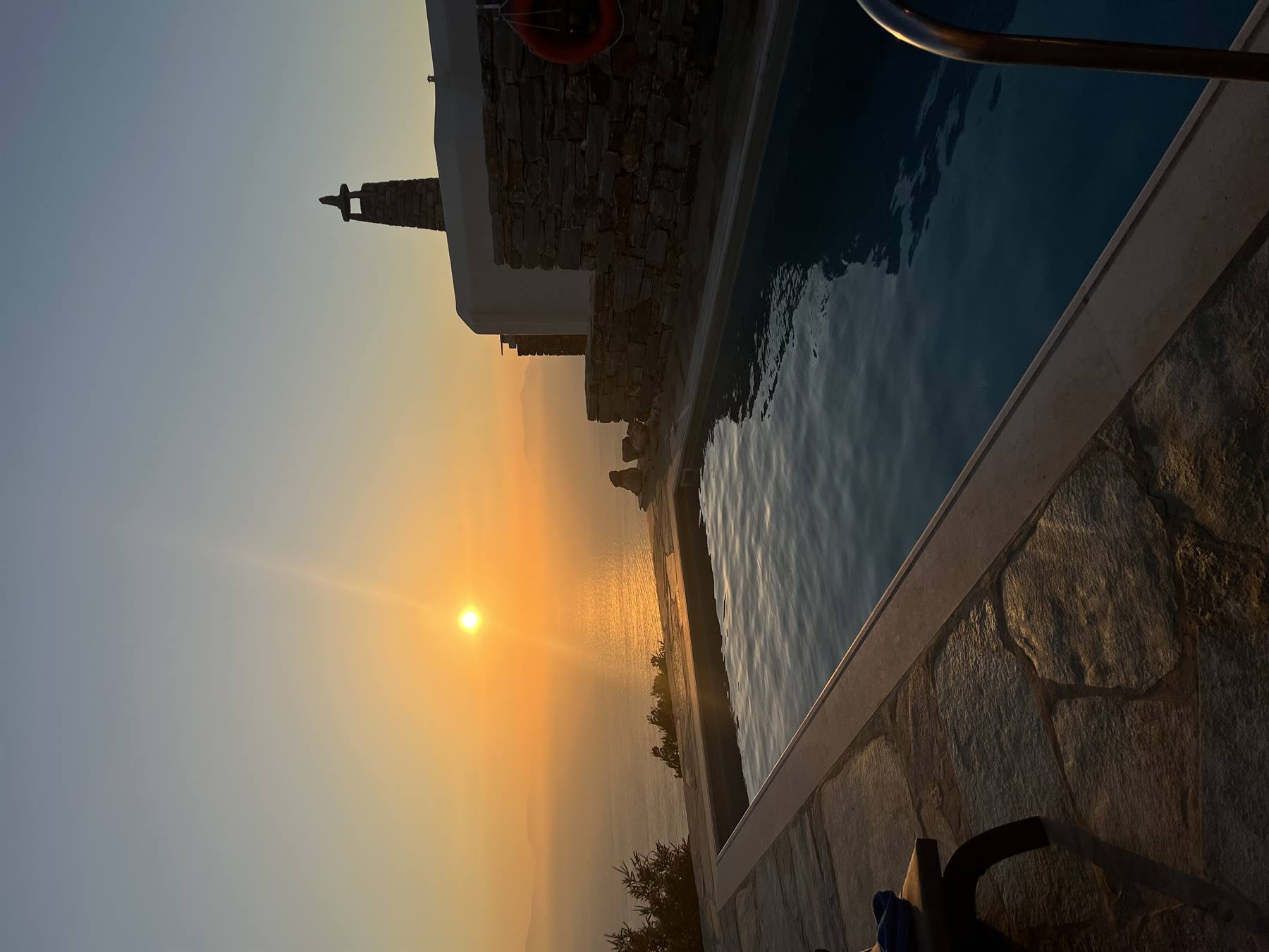 Il sole tuffandosi nel mare, accanto alla piscina: momento sospeso nel cuore.