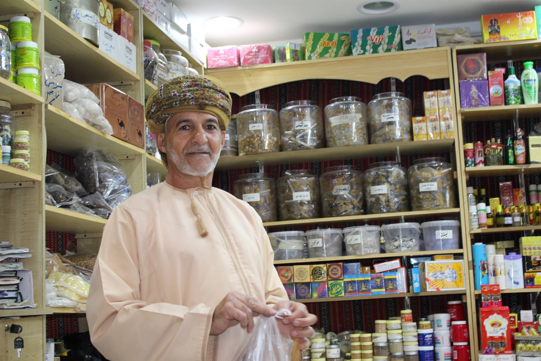 Il sorriso più caldo del souk, tra barattoli di spezie e mille profumi.