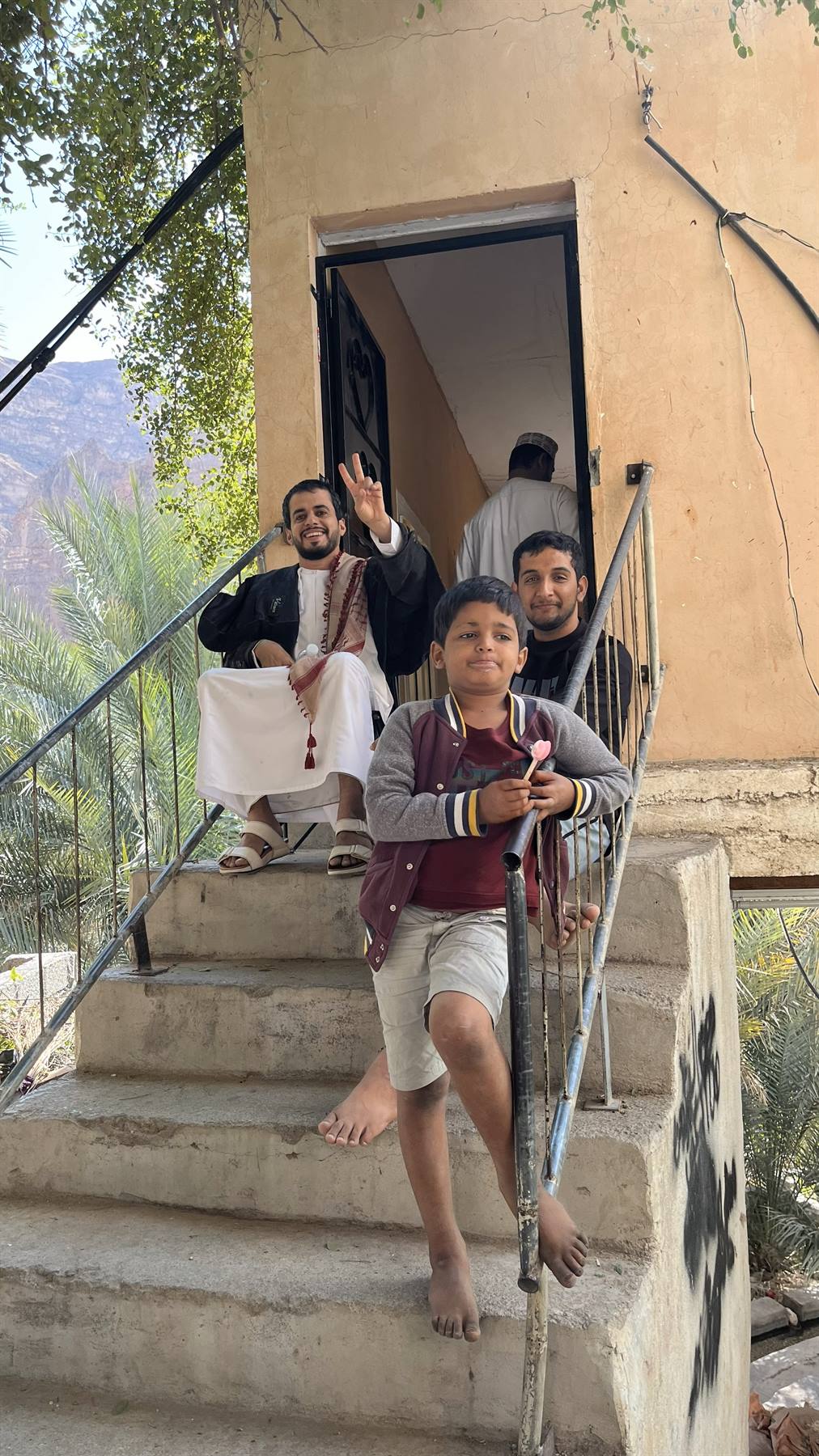 Sorrisi e saluti caldi sulle scale di casa, tra le montagne.