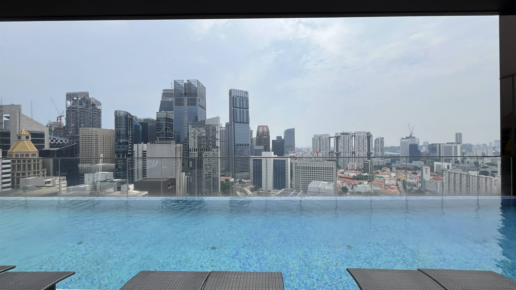 Pomeriggio lento sulla piscina, con gli skyline di Singapore a fargli da specchio.