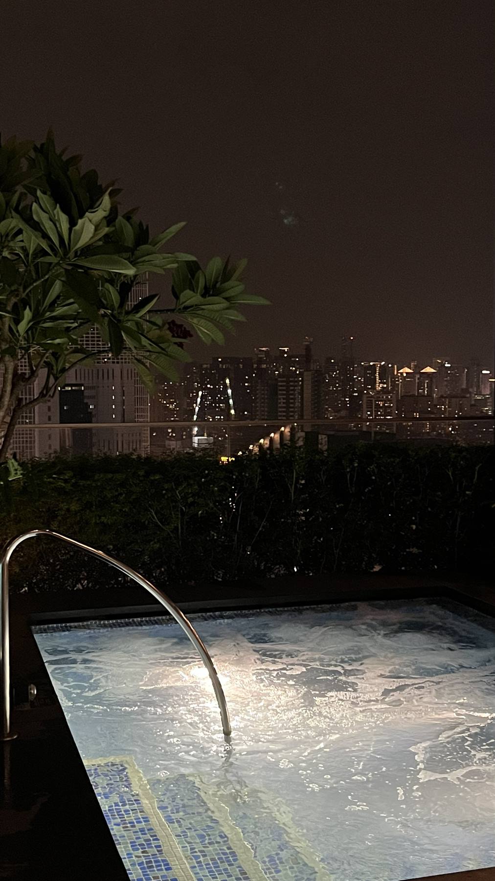 Una piscina calda e la città che brilla nel buio.