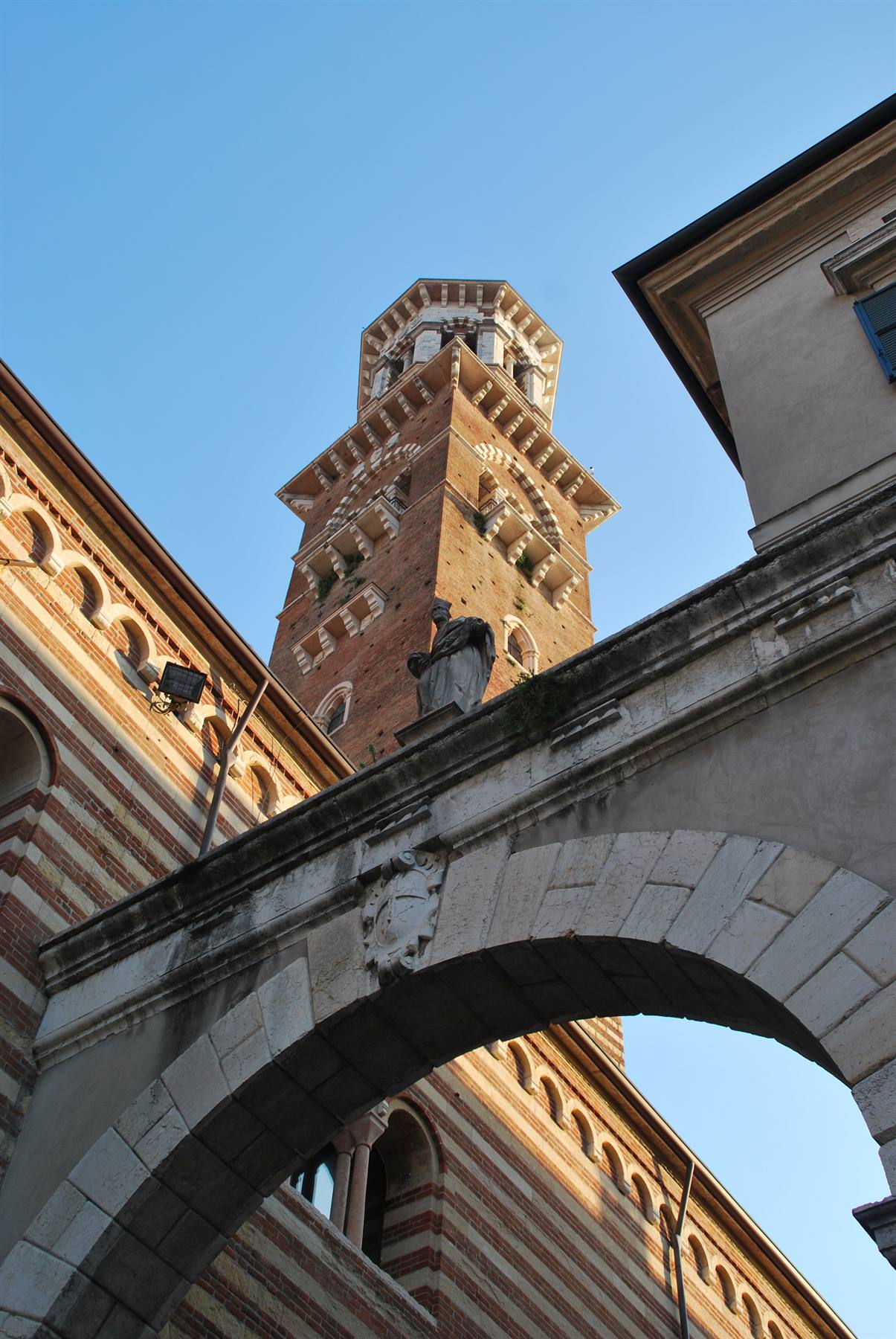 Torre dei Lamberti a Verona vista dall'arco in mattoni rossi e bianchi