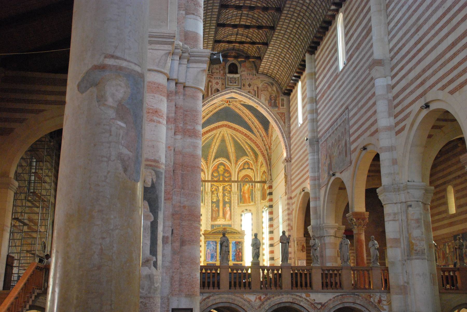 Interno della basilica di San Zeno a Verona, colonne in pietra, affreschi e statue