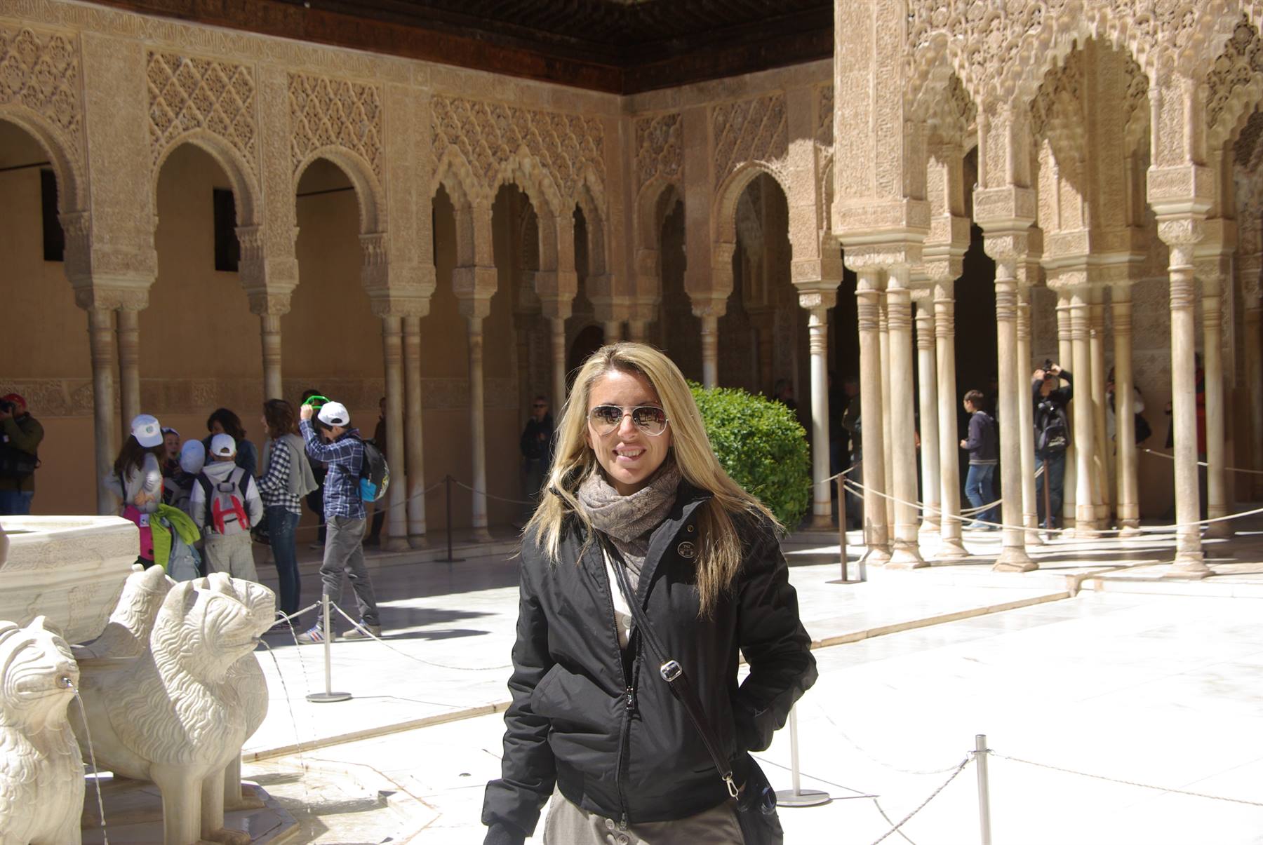 Donna sorridente nel Cortile dei Leoni, l'Alhambra, tra archi e colonne di marmo