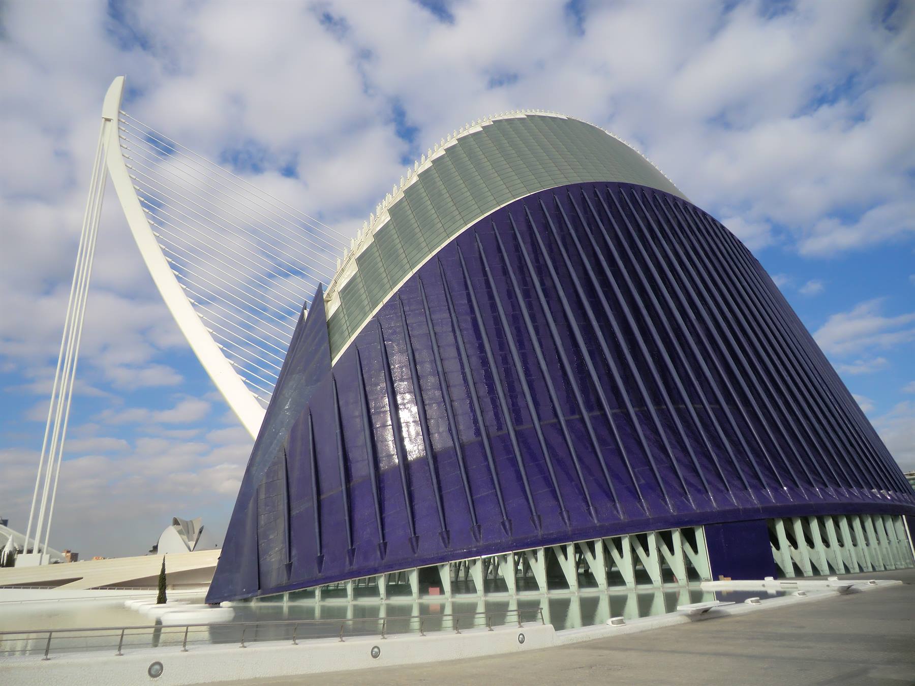 L'Àgora di Calatrava a Valencia: cupola azzurra e ponte sospeso bianco sotto nuvole