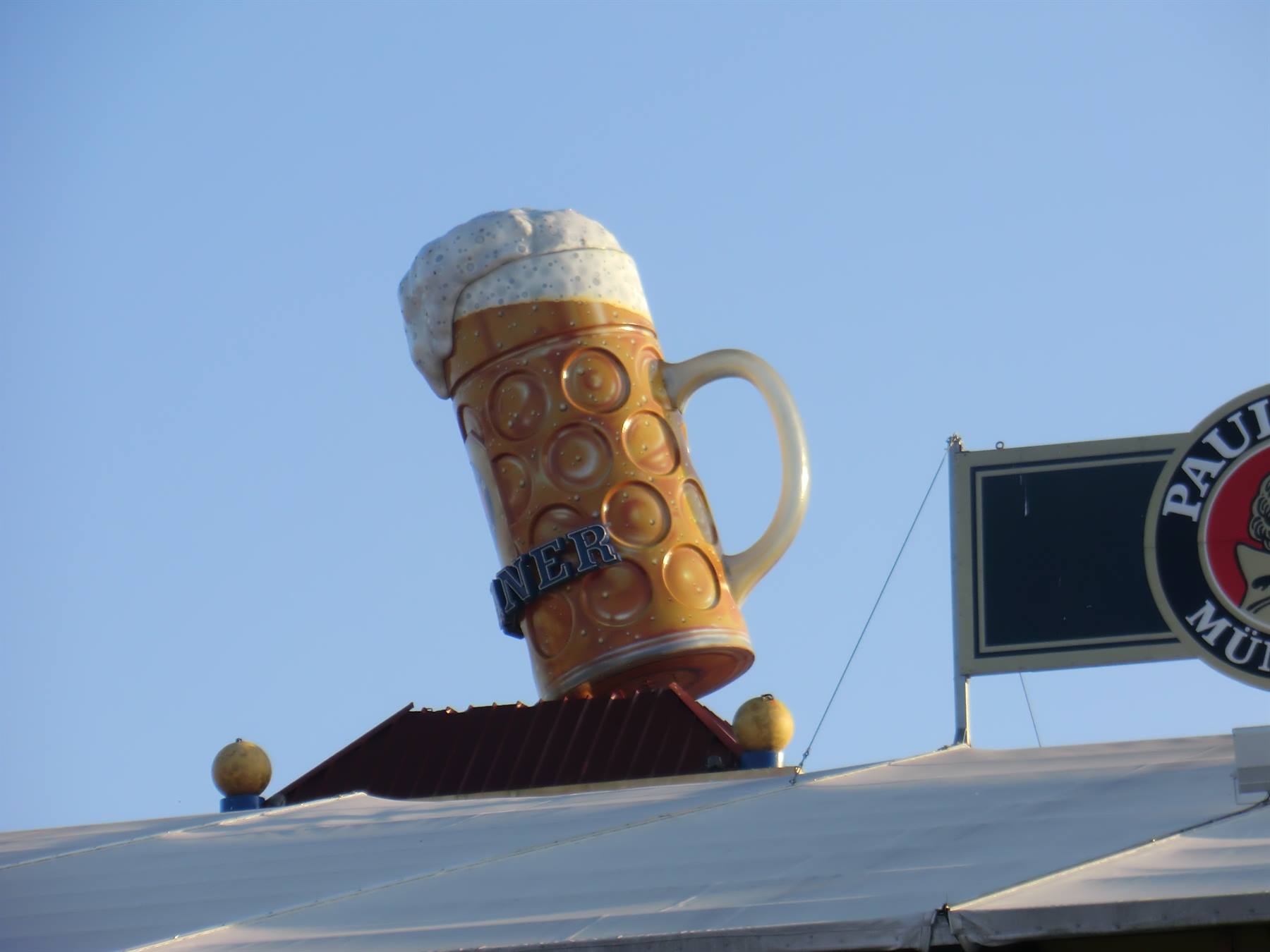 Enorme boccale di birra in plastica sul tetto della tenda Paulaner, Monaco