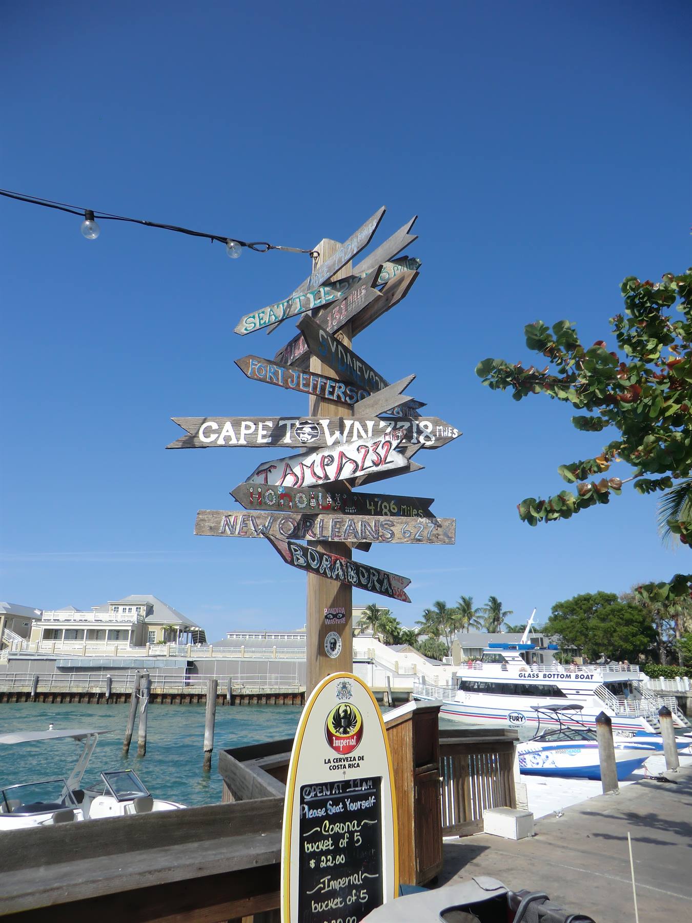 Palo con indicazioni di legno verso Cape Town e New Orleans sul porto di Key West