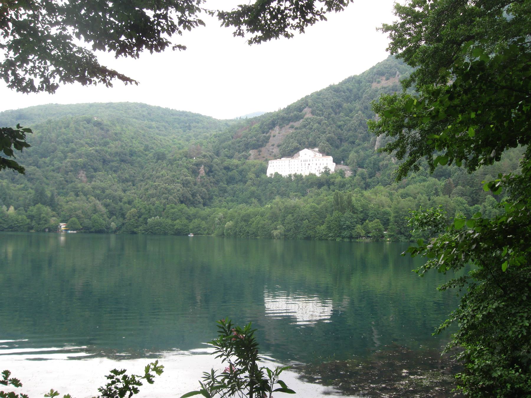 edificio bianco sul bosco si riflette nel lago verde di Monticolo