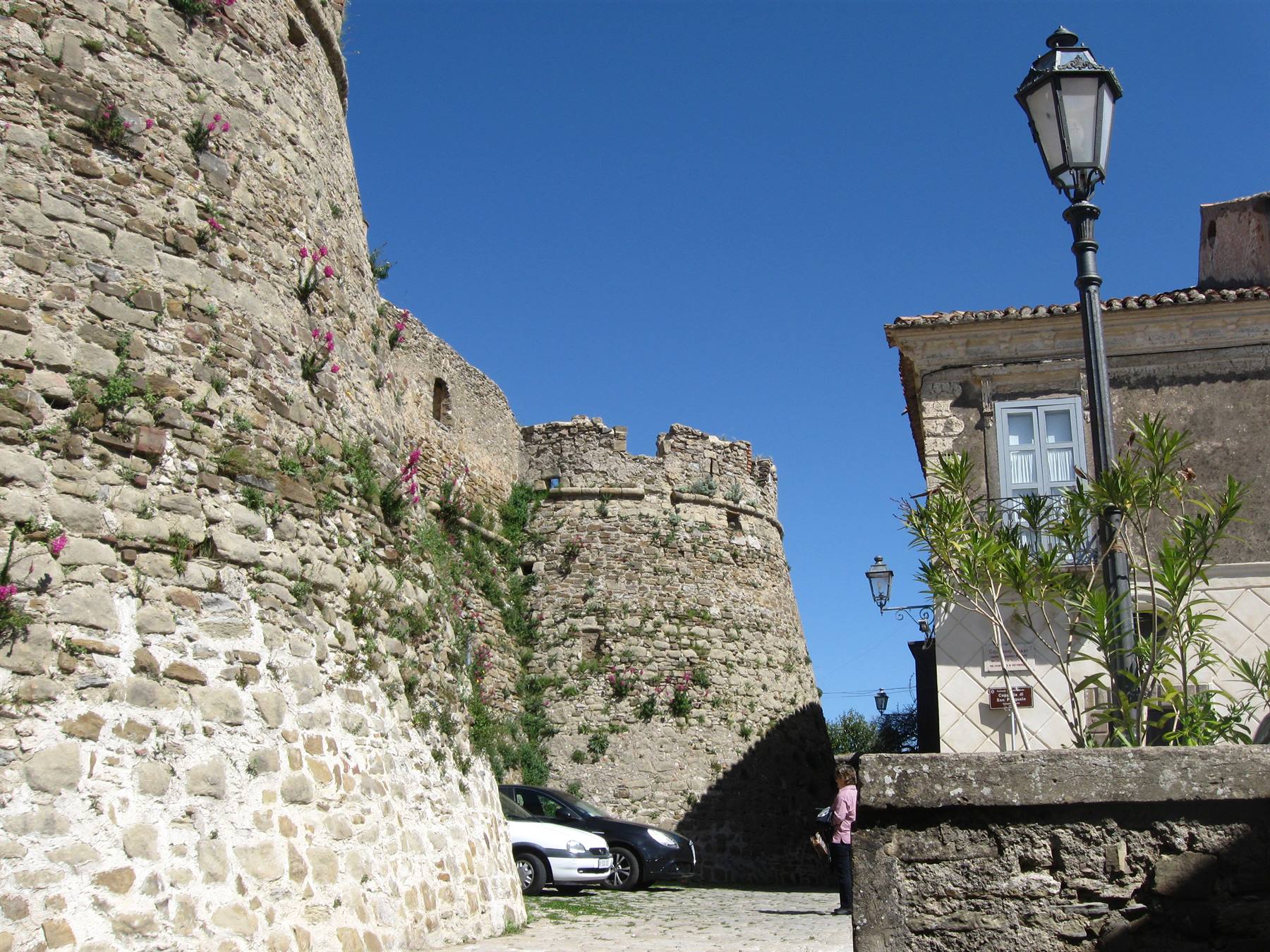 Mura del castello aragonese a Vasto, pietra a vista, auto ferma sotto il cielo azzurro