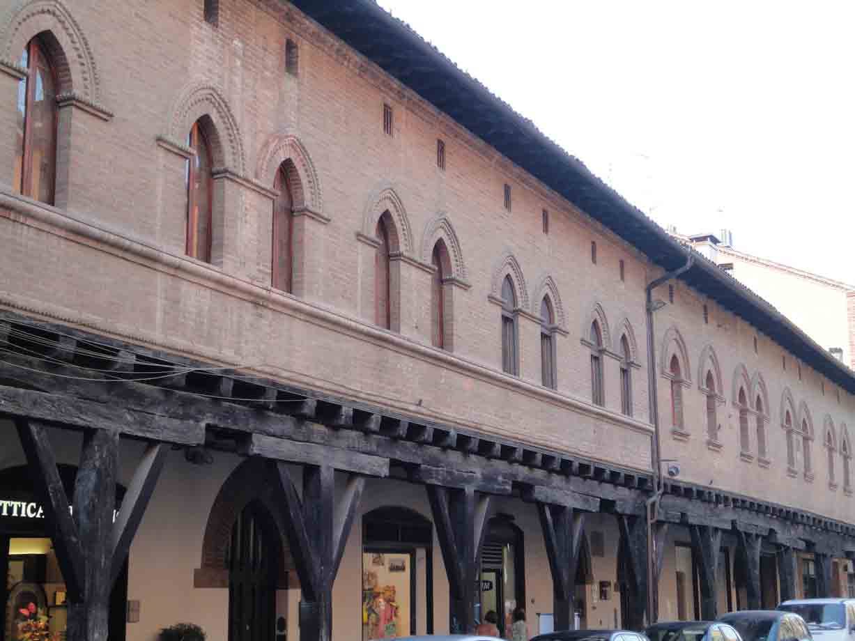 Palazzo in mattoni con trifore gotiche e portico di travi di legno a Bologna