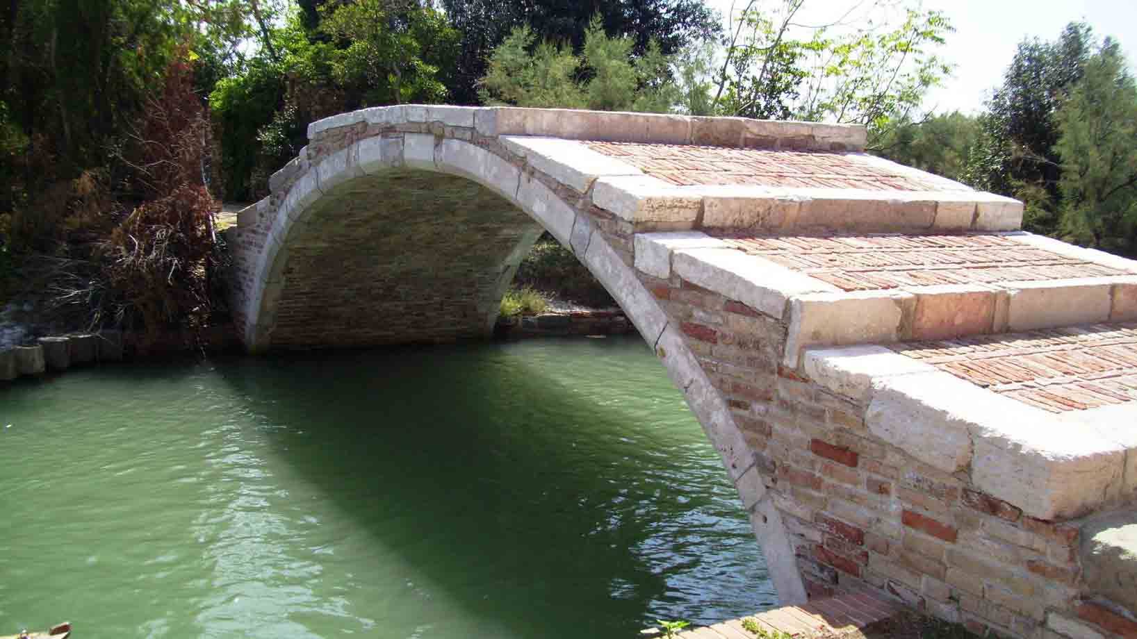 Ponte del Diavolo a Torcello: arcata in pietra e mattoni sul canale verde