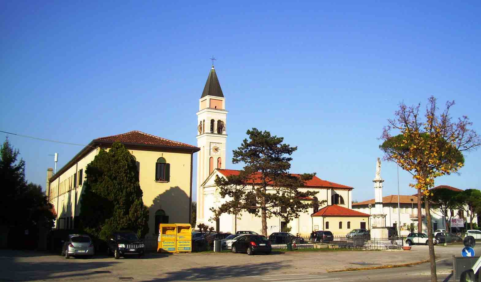Chiesa bianca con campanile e piazza al sole