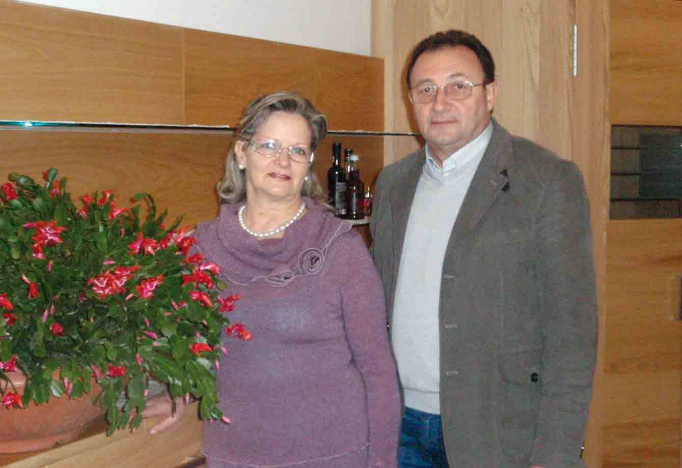 Coppia in salotto accanto a un cactus di Natale fiorito in vaso