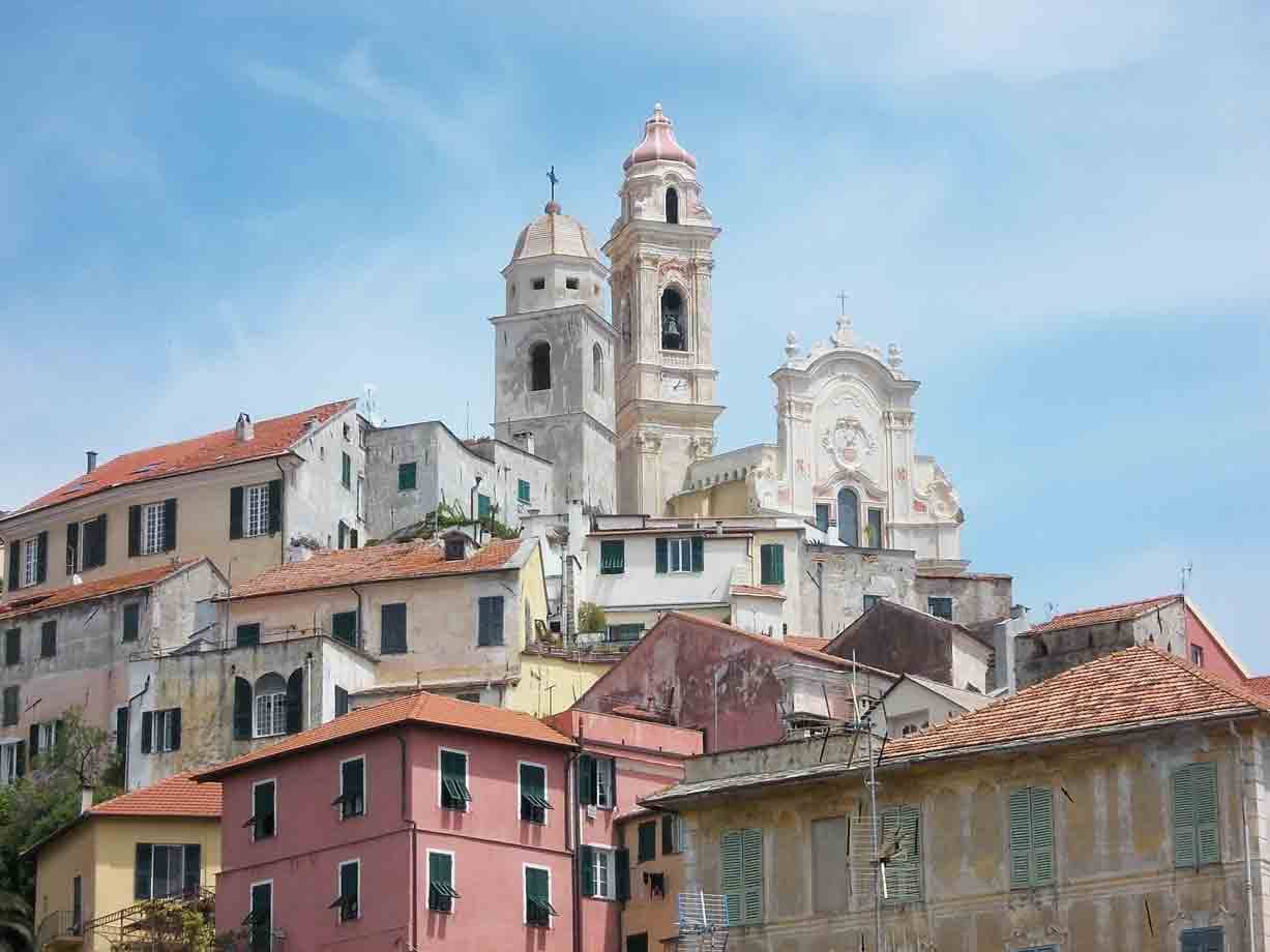 Case colorate in salita e chiesa barocca con due campanili, Cervo