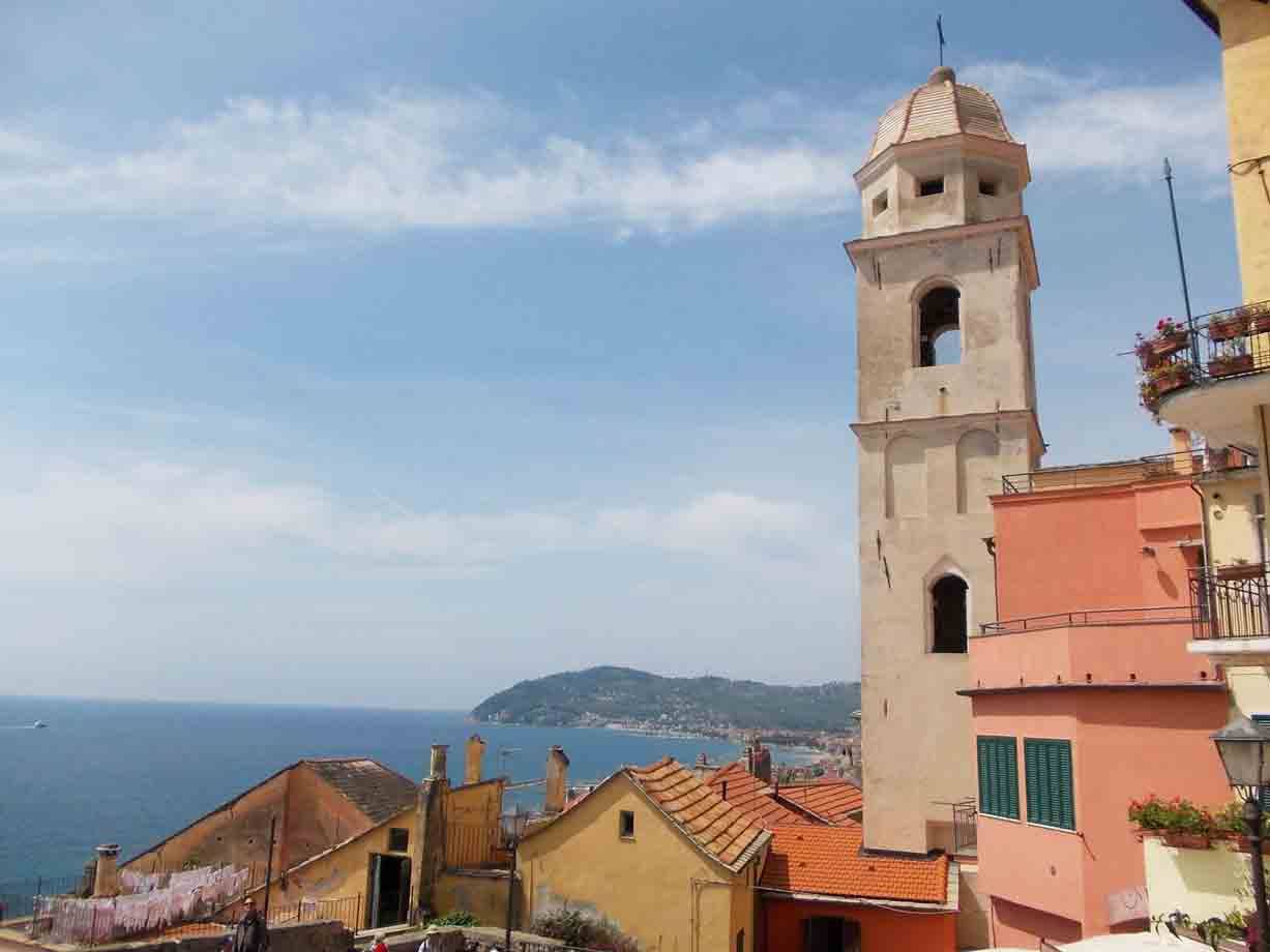 Campanile e case colorate sopra il mare, costa ligure