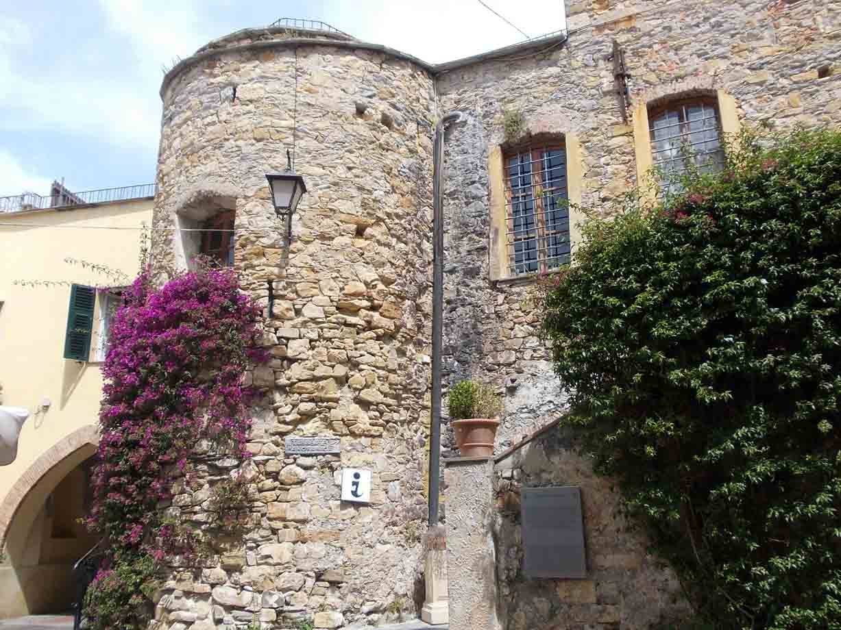 Torre medievale in pietra con bouganville fiorita nel borgo antico di Sestri Levante
