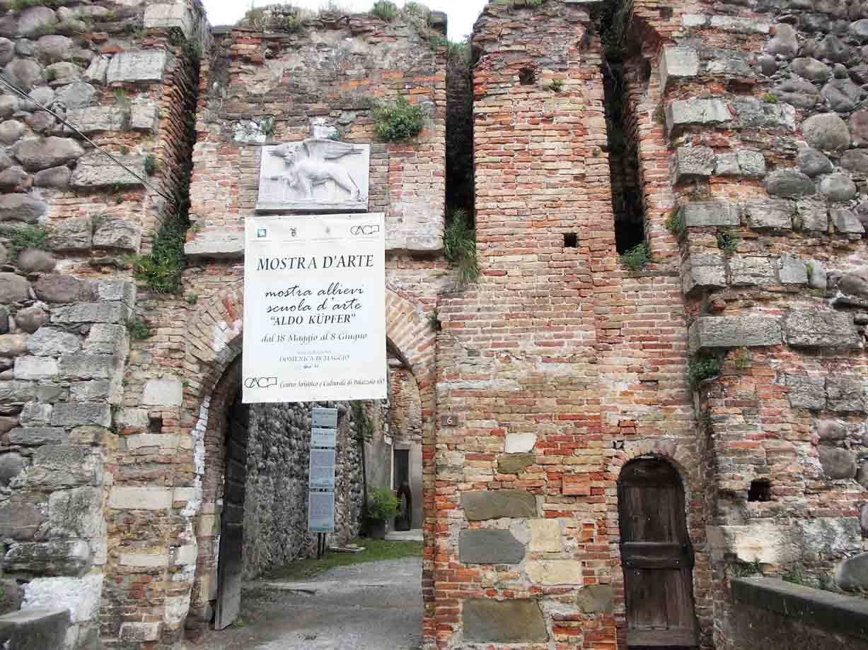 Antico portale di mattoni e pietre con cartello della mostra d'arte