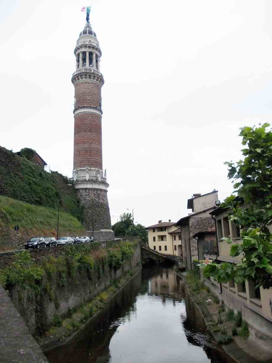 Torre Civica in mattoni su collina verde, canale Scarpatetti con case tra Busto Arsizio