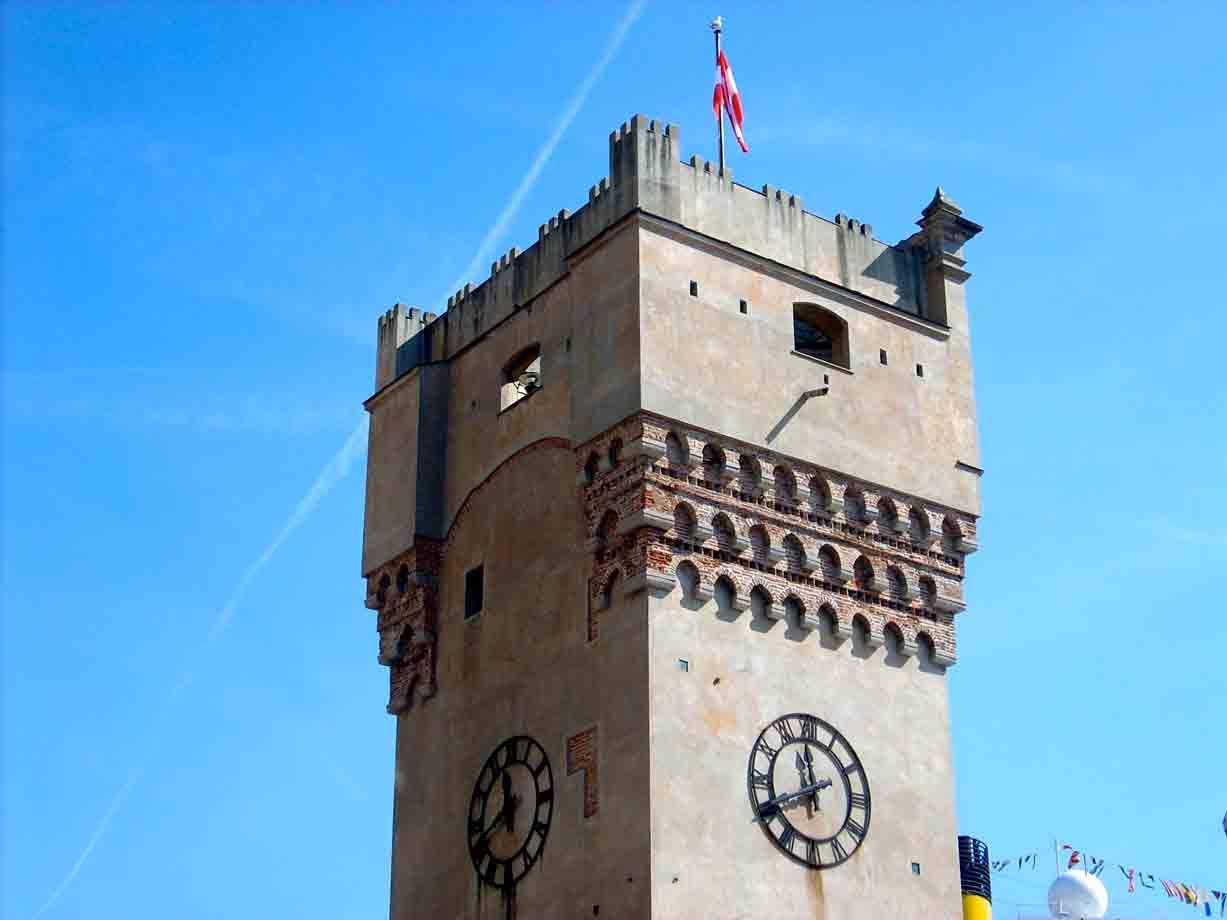 Torre Apponale a Riva del Garda, pietra e mattoni, orologi e bandiera al vento
