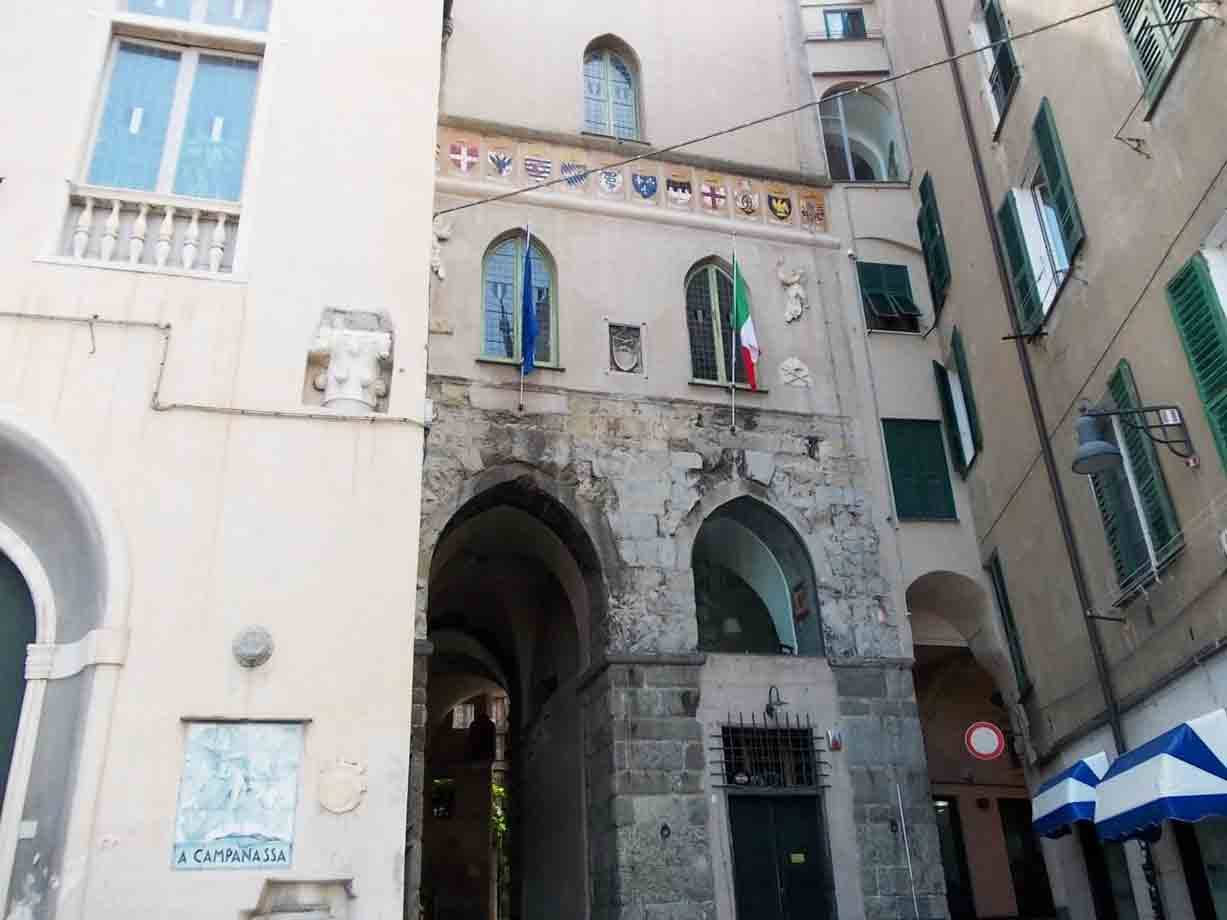 Porta dei Vacca a Genova, torri in pietra con archi e bandiere