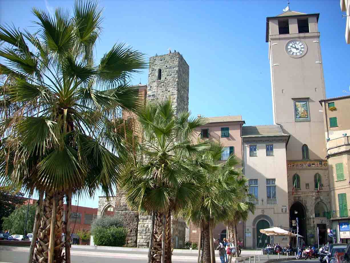 Palme davanti alla torre civica con orologio e torre medievale di piazza a Rapallo